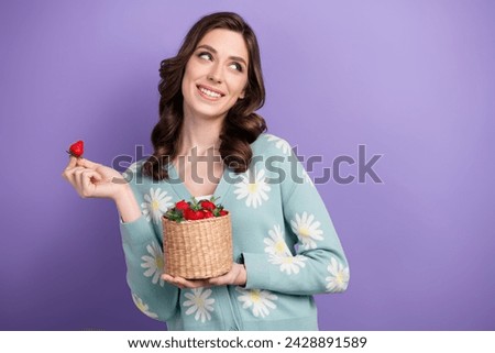 Photo of excited dreamy lady dressed flower print cardigan eating berries looking empty space isolated violet color background