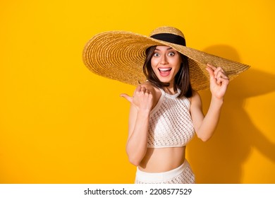 Photo of excited funky girl dressed knitted look sunhat open mouth pointing thumb back empty space isolated yellow color background - Powered by Shutterstock