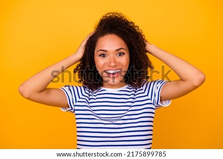 Photo of excited funky girl dressed striped t-shirt hands arms head smiling isolated yellow color background