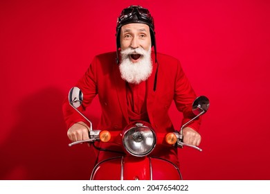 Photo Of Excited Funky Santa Claus Ride Bike Omg Reaction Open Mouth Wear Goggles Helmet Suit On Red Color Background