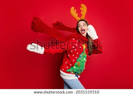 Photo of excited funky young lady wear ornament sweater smiling looking empty space isolated red color background