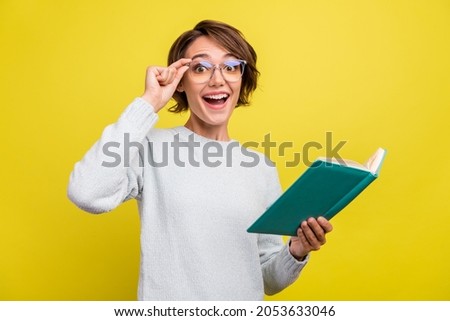 Photo of excited funny nerd lady read book open mouth wear eyewear blue pullover isolated yellow color background