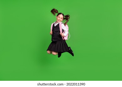 Photo Of Excited Funny School Girl Wear Black White Uniform Backpack Jumping High Smiling Isolated Green Color Background