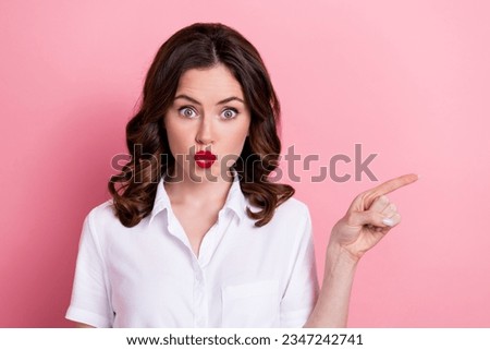Photo of excited funny young lady wear white shirt pouted lips showing finger empty space isolated pink color background