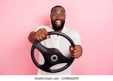 Photo Of Excited Positive Man Hold Wheel Open Mouth Enjoy New Car Ride Isolated On Pink Color Background