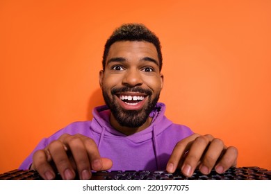 Photo of excited positive person hands typing keyboard toothy smile isolated on orange color background - Shutterstock ID 2201977075