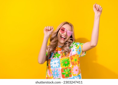 Photo excited pretty lady dancing summer youth party festival wear heart sunglass print shirt isolated yellow color background - Powered by Shutterstock