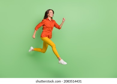 Photo Of Excited Sweet Mature Lady Dressed Red Shirt Jumping High Running Fast Empty Space Smiling Isolated Green Color Background