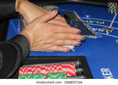 A Photo Of A Female Dealer With Grey Purple Nail Polish Getting Ready To Deal A Game Of Baccarat On A Game Table With Gambling Chips.