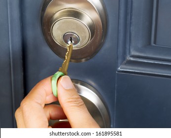 Photo Of Female Hand Putting House Key Into Front Door Lock Of House