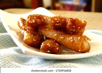 Photo Of Filipino Food Called Turon Or Deep Fried Saba Banana In Spring Roll Wrapper With Brown Sugar And Sesame Seeds.