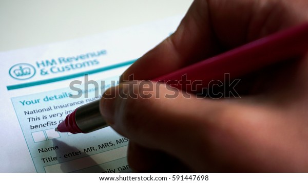 Photo of filling in a\
HM customs form a personal details for UK self assessment tax and\
benefits right.