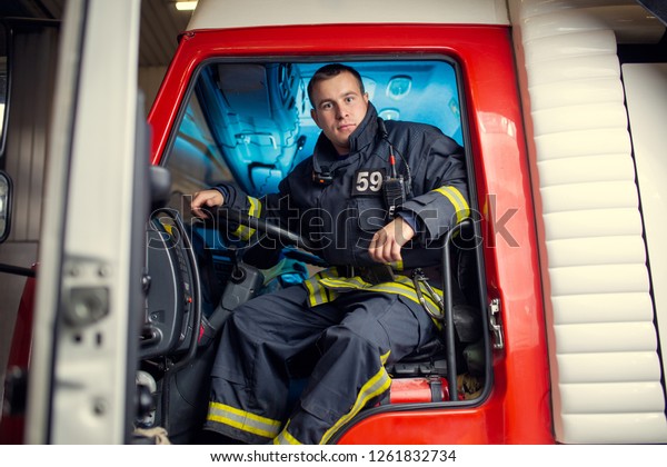 Photo of fireman man\
sitting in fire truck