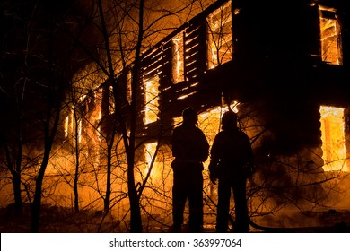 Photo Of Firemans Trying To Safe House On Fire. Firefighter Emergency Extinguish Water On Big Old Wooden House On Fire