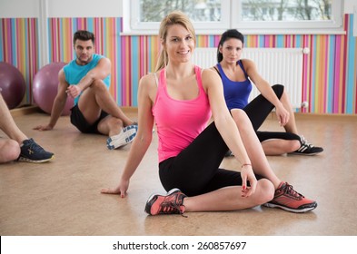 Photo of fit people stretching legs during fitness classes