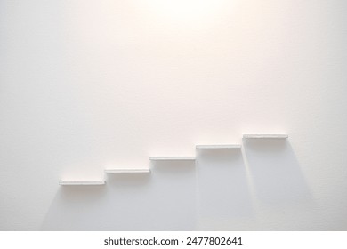 A photo of five white steps mounted on a white wall, symbolizing the way to success.