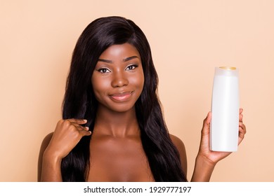 Photo of flawless natural brunette lady hold bottle gel shampoo look camera hand touch hair isolated beige background