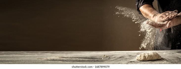 Photo of flour and men hands with flour splash. Cooking bread. Kneading the Dough. Isolated on dark background. Empty space for text.