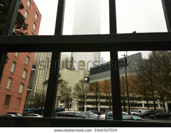 Photo of\
the foggy downtown buildings through the\
gate