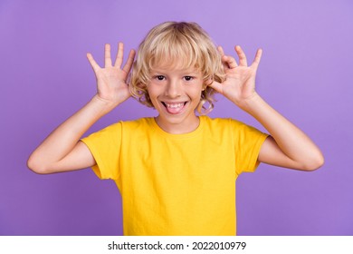 Photo of foolish funny funky blonde kid boy have fun wear yellow t-shirt isolated violet color background - Shutterstock ID 2022010979