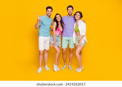 Photo of four people best fellows have fun together on weekends make v sign isolated bright color background