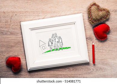 Photo Frame With Happy Family Drawing On Wooden Table