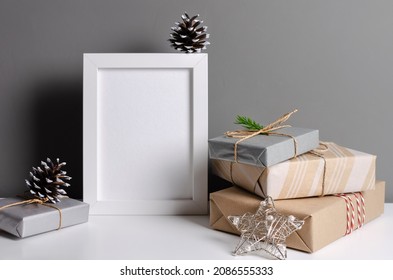 Photo Frame Mockup With Pile Of Decorated Christmas Gift Boxes Over Grey Wall