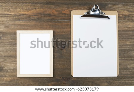 Photo frame next to a folder with sheets of paper. Horitzontal shoot.