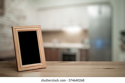 Photo Frame On The Wooden Table  In The Kitchen