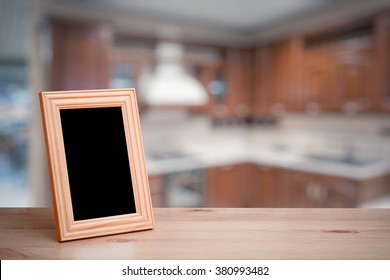 Photo Frame On The Wooden Table  In The Kitchen