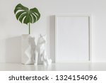 Photo frame and origami vase and fox scultpure decor near white wall. Mock up
