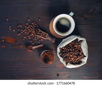 Photo Of Fresh Tasty Coffee On Vintage Wood Table Background. Coffee Cup, Coffee Beans In Canvas Bag And Ground Powder. Top View. Flat Lay.