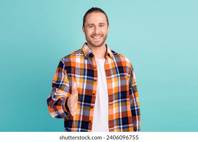 Photo of friendlu cheerful nice man with stubble dressed checkered shirt stretching arm to you greetings isolated on teal color background - Powered by Shutterstock