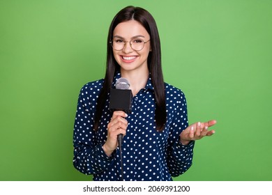 Photo Of Friendly Brunette Hairdo Journalist Lady Talk In Mic Wear Spectacles Blue Shirt Isolated On Green Color Background