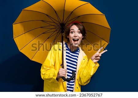 Photo of friendly funky laughing good mood girl demonstrate v sign bring umbrella protect against storm isolated on blue color background