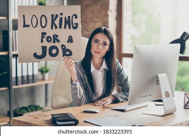 Photo Of Frustrated Sad Upset Girl Marketer Sit Desk Table Lost Job Covid Quarantine Market Crisis Hold Cardboard Text Look For Job Wear Grey Blazer In Workstation Office