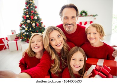 Photo Of Full Big Family Five People Meeting Three Little Kids Hold Present Box Bow Ribbon Mom Make Shoot Selfie Wear Red Jumper In Living Room X-mas Tree Lights Many Gifts Indoors