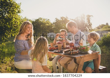 Photo of full big family five people three little kids sit bench table relax delicious dinner eat sandwich apples salad generation sunny weekend comfort home park backyard outdoors
