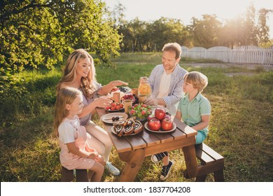 Photo Of Full Big Family Four People Gathering Sit Bench Relax Breakfast Table Drink Citrus Juice Eat Fruits Vegetables Salad Generation Warm Weather Comfort Home Park Backyard Outdoors