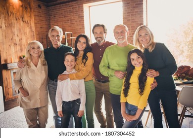 Photo Of Full Family Gathering Eight People Two Little Kids Waiting Blessing Cheerful Shiny Beaming Smile Cuddle Embrace Fall Season October Generation In Home Evening Living Room Indoors