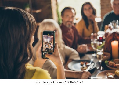 Photo Of Full Family Gathering Small Daughter Hold Telephone Make Adorable Picture Digital Camera Focusing Push Button Dinner Big Table Turkey Generation In Home Evening Living Room Indoors