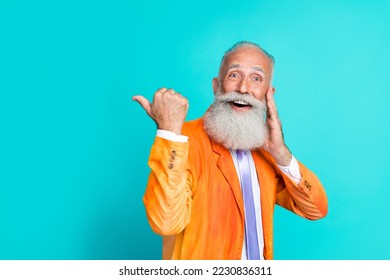 Photo of funky astonished person hand touch cheek indicate finger empty space isolated on aquamarine color background