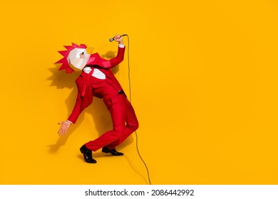 Photo of funky carefree incognito guy hold mic sing song wear rooster mask red tux isolated yellow color background - Shutterstock ID 2086442992