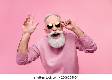 Photo Of Funky Cool Mature Man Dressed Pullover Arm Dark Glasses Smiling Waving Arm Hello Isolated Pink Color Background