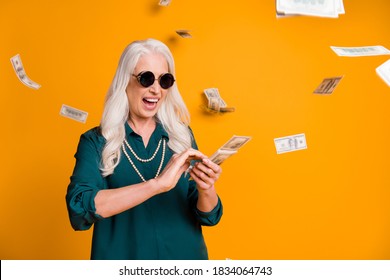 Photo Of Funky Crazy Grandma Lady Pack Usa Bucks Hands Money Fall Sky Wealthy Person Spend Money Luxury Wear Green Shirt Sun Specs Necklace Isolated Bright Yellow Color Background