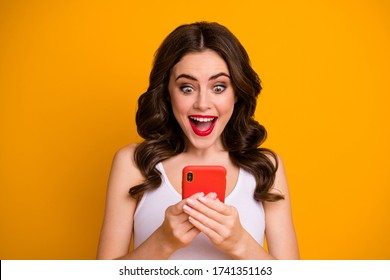 Photo of funky crazy millennial lady open mouth hold telephone read positive blog post comments new followers wear casual white singlet isolated bright yellow color background