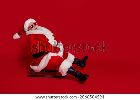 Photo of funky crazy old man ride sleigh have x-mas fun wear santa hat costume isolated red color background
