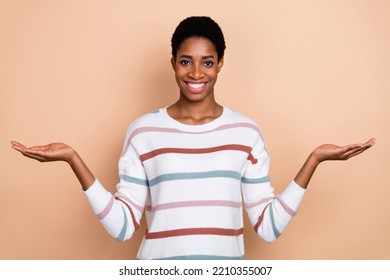 Photo Of Funky Cute Young Unisex Person Wear Sweater Comparing Arms Empty Space Isolated Beige Color Background