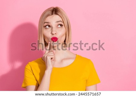 Photo of funky dreamy lady dressed yellow t-shirt finger chin lips pouted looking emtpy space isolated pink color background