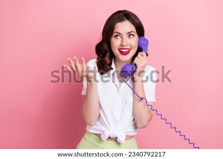 Photo of funky dreamy young lady wear white shirt speaking retro telephone looking empty space isolated pink color background